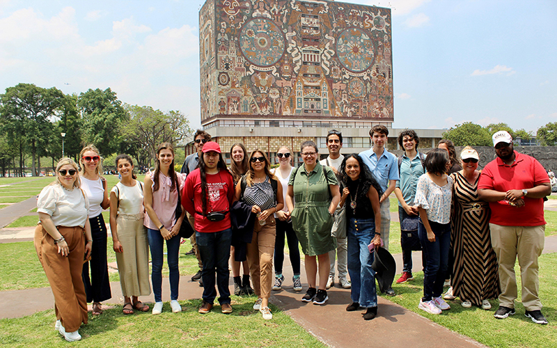 A group of people stand in front of a colorfully painted building.