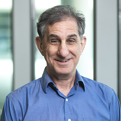 A man in a blue shirt smiles at the camera.